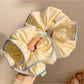 Chic yellow hair scrunchie with white stripes on a white background