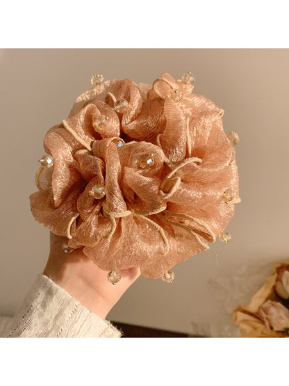Gifty scrunchie worn on a wrist, showcasing vintage beads and gathered fabric design