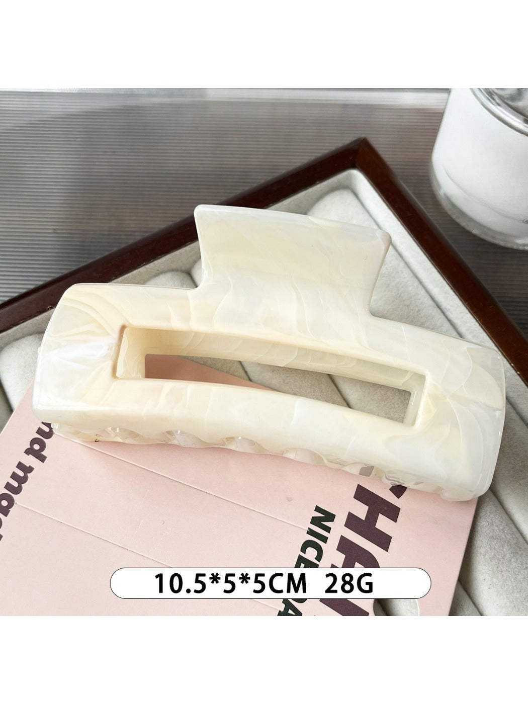 Beau marble pattern square claw clip with light reflecting off its glossy finish