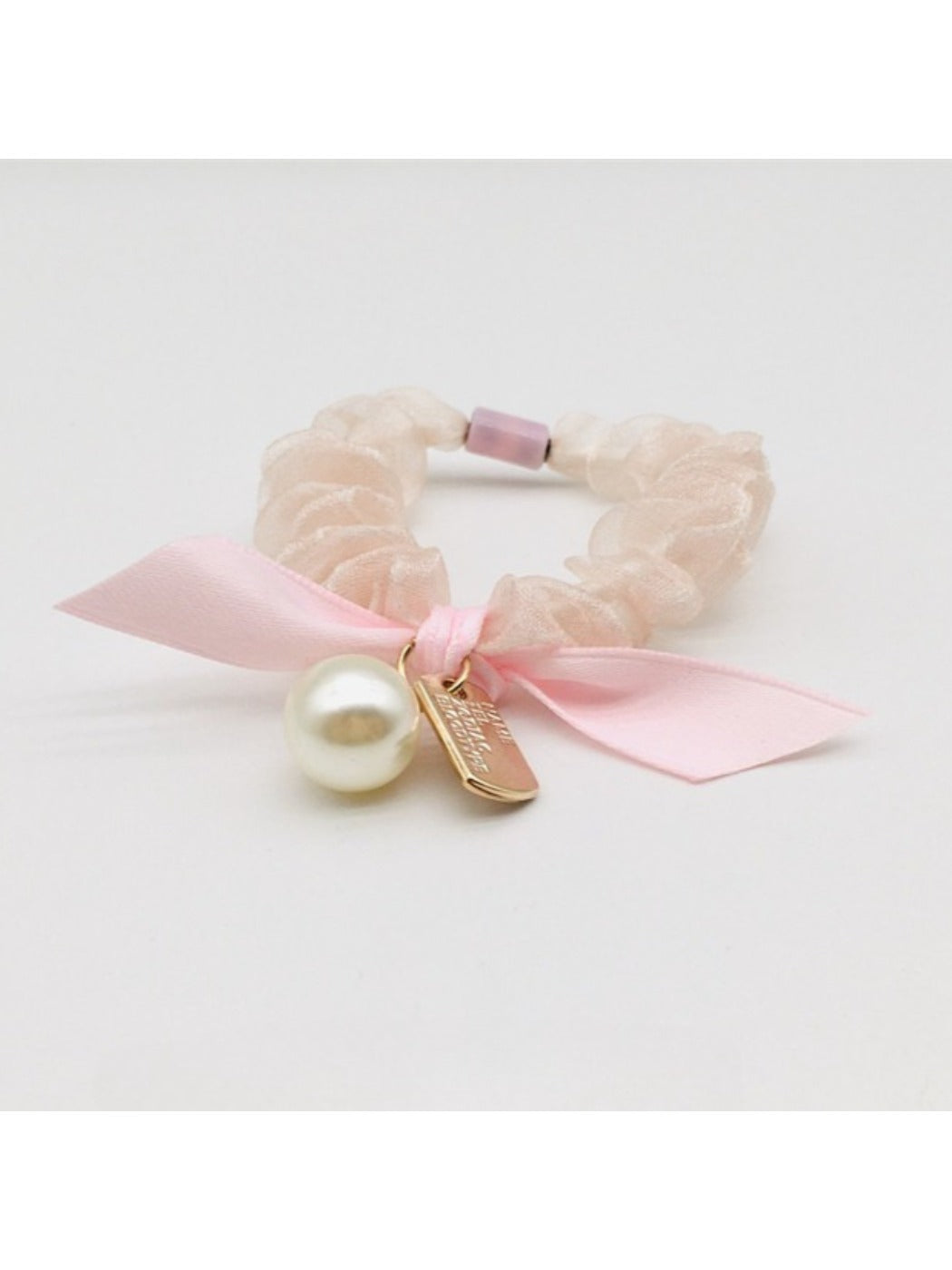 Gifty Sweet Bow Embellished Hair Tie styled in a ponytail on a model with dark hair