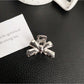 Beau classic bow hair clip attached to a ponytail on model with dark hair