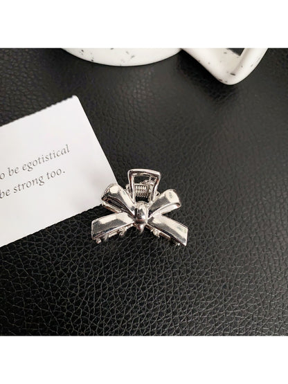 Beau classic bow hair clip attached to a ponytail on model with dark hair