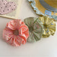 Gifty color block stripe scrunchie styled on a wrist as an accessory