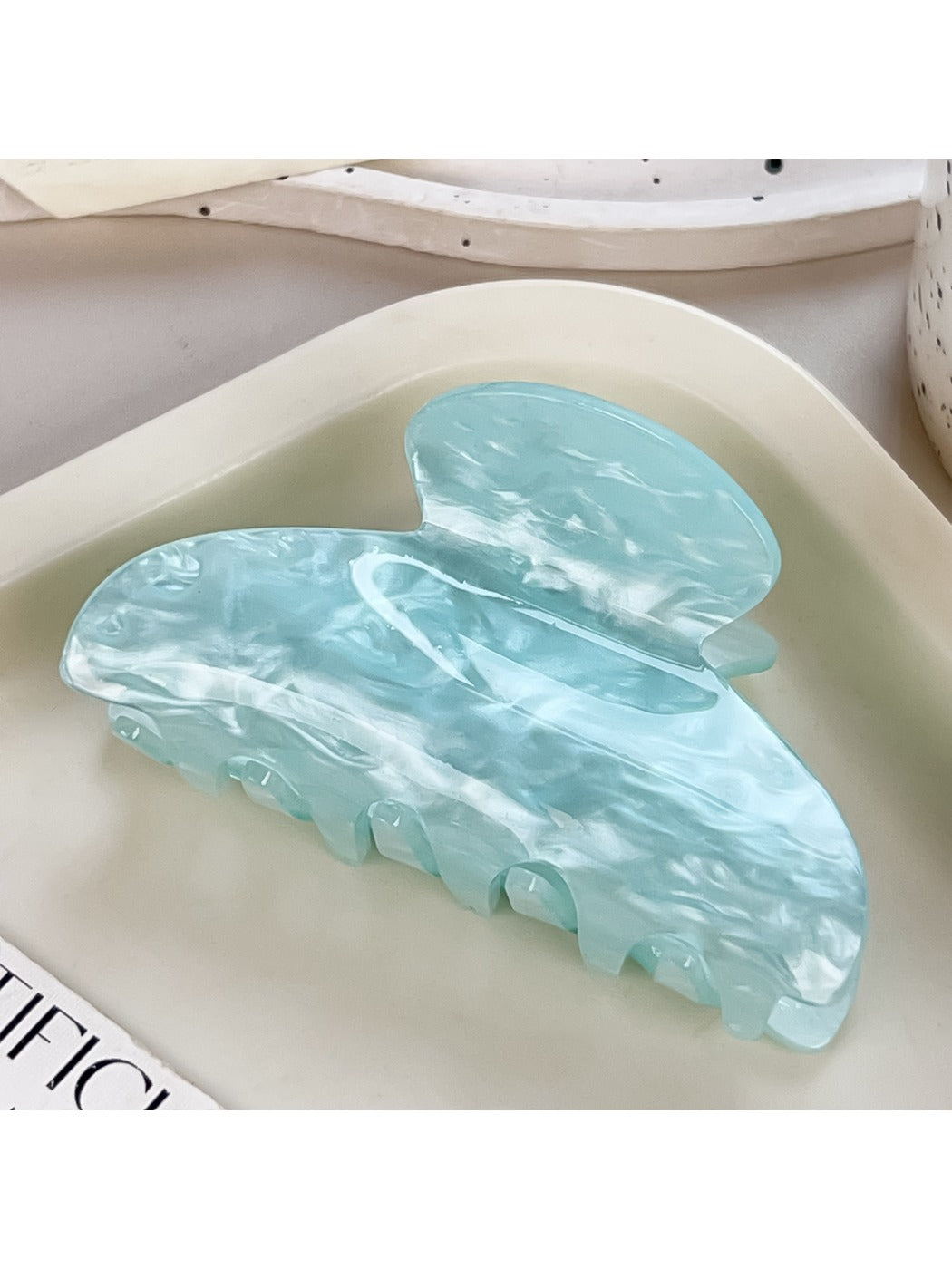 Beau claw clip placed next to matching pastel accessories