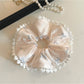 Side view of Gifty satin scrunchie featuring pink bow pattern
