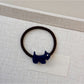 Gifty hair tie with cartoon puppy charm placed on a white background