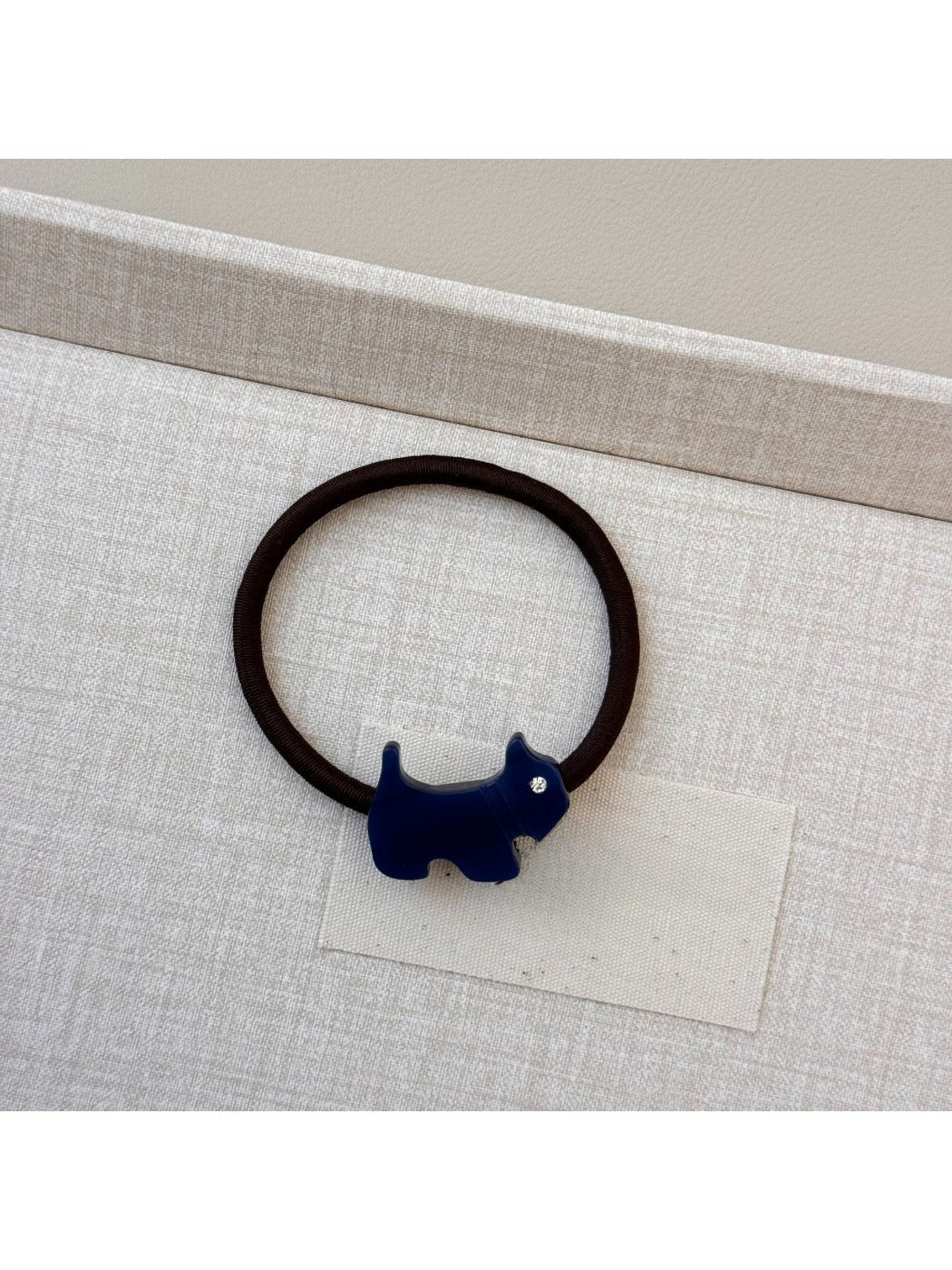 Gifty hair tie with cartoon puppy charm placed on a white background