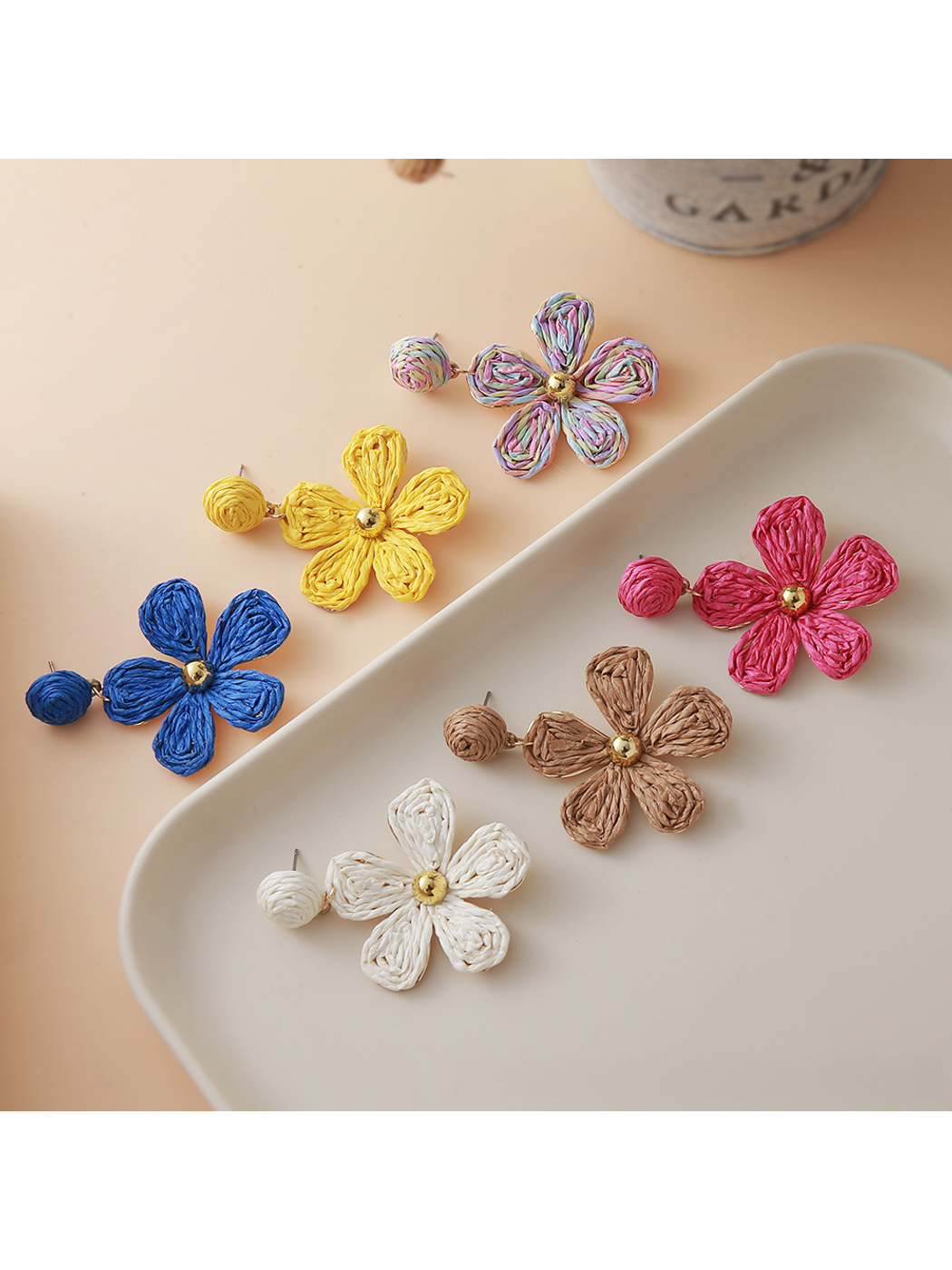 Close-up of Earedge floral raffia woven vintage drop earrings on white background
