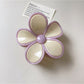 Beau claw clip resting on fabric surface highlighting smooth finish and colors