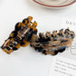 Beau claw clip holding thick brown hair in a half-up hairstyle