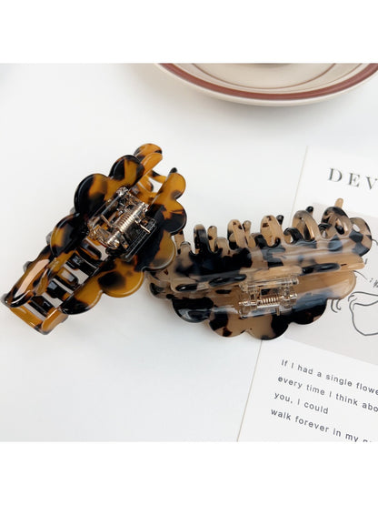 Beau claw clip holding thick brown hair in a half-up hairstyle