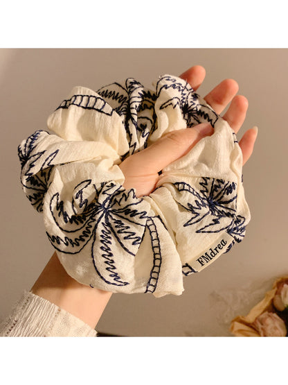 Close-up of coconut tree design on vintage print scrunchie