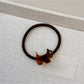 Gifty hair tie with cartoon puppy embellishment held between fingers