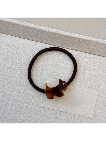 Gifty hair tie with cartoon puppy embellishment held between fingers
