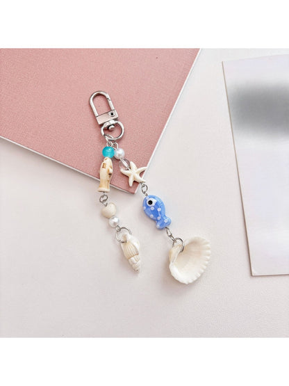 Blue fish keychain held in hand displaying size and shape
