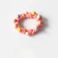 Colorful beaded hair ties wrapped around a wrist as a bracelet accessory