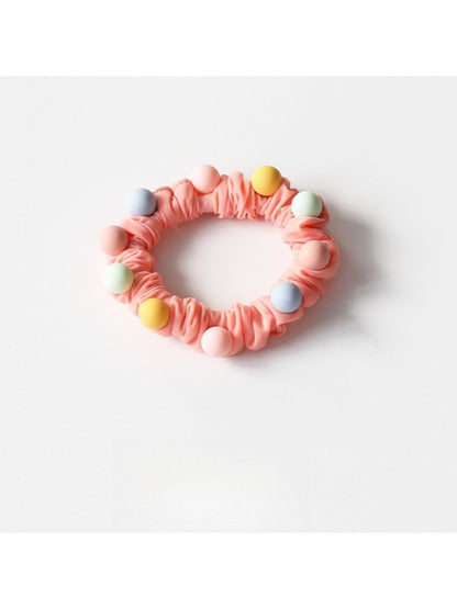 Colorful beaded hair ties wrapped around a wrist as a bracelet accessory
