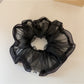 Gifty scrunchie stretched slightly to show elasticity and fabric quality