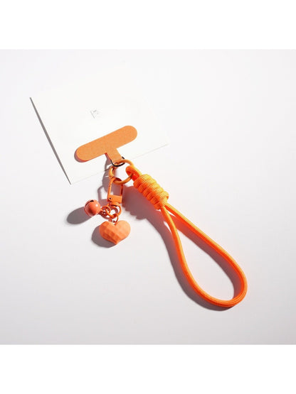 Candy color heart keychain held in hand showing size relative to fingers