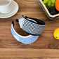 Close-up of Gifty plaid bow print headband showing fabric texture and pattern