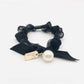 Gifty Sweet Bow Embellished Hair Tie worn on a model's wrist with soft lighting
