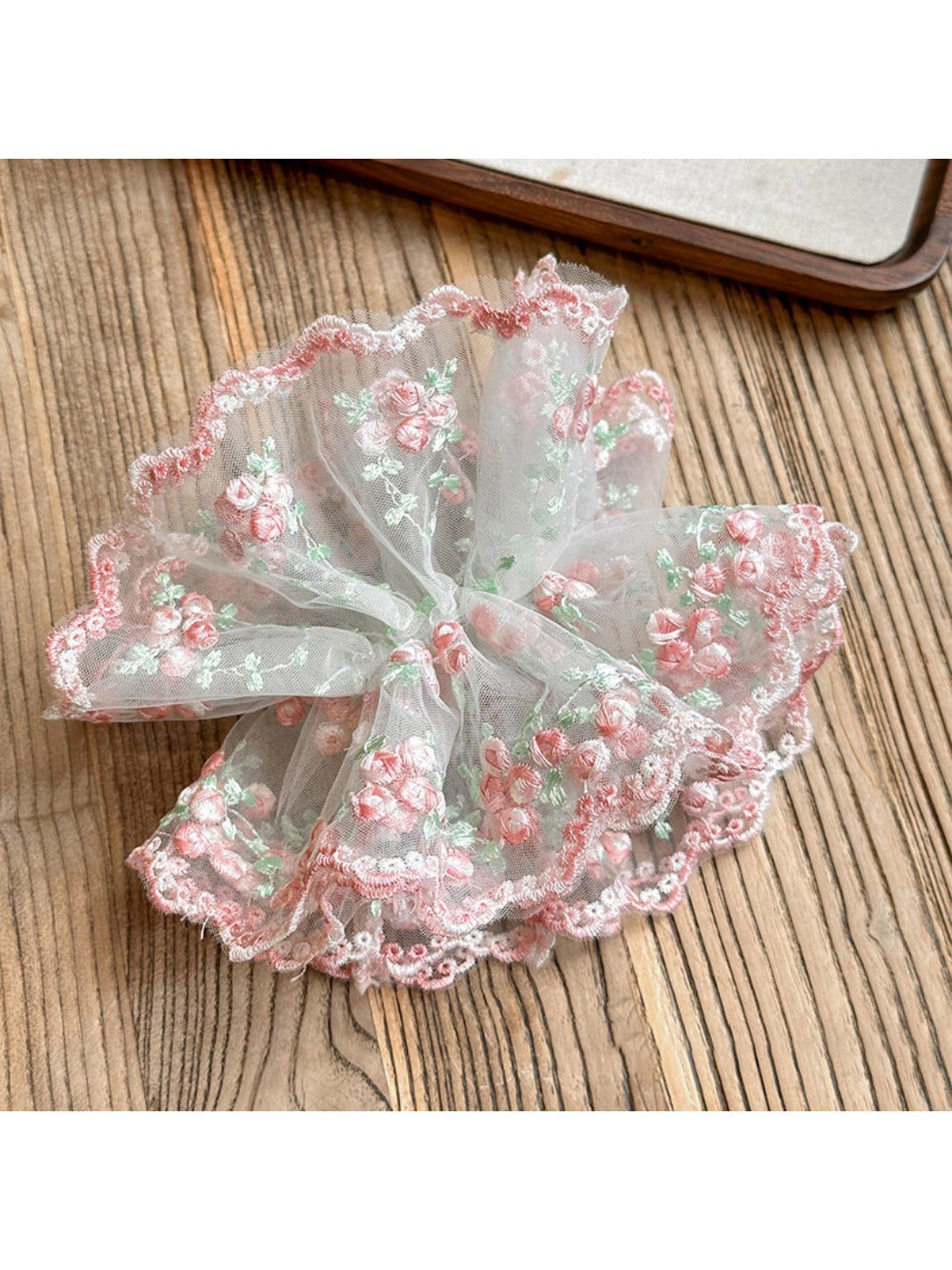 Side view of the pink ruffled scrunchie showing fabric texture