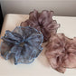 Side view of large pink tulle scrunchie with shimmering glitter