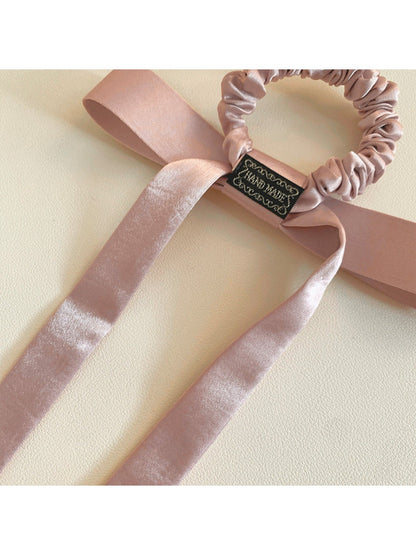 Flat lay of the bow embellished hair tie showing its elastic band and fabric texture