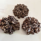 Side view of leopard print scrunchie highlighting gathered fabric texture