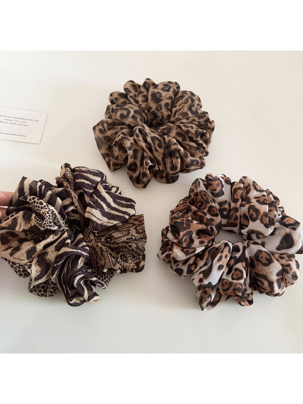 Side view of leopard print scrunchie highlighting gathered fabric texture