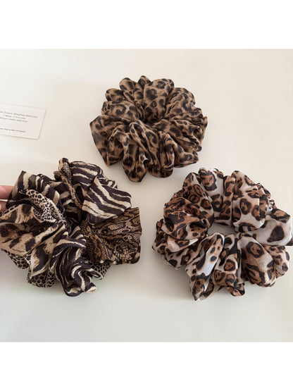 Side view of leopard print scrunchie highlighting gathered fabric texture