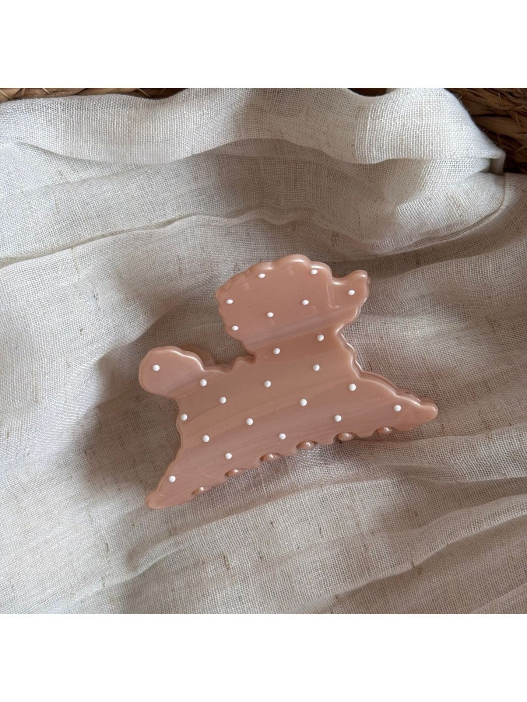 Side view of Beau polka dot puppy hair clip displaying its curved shape and clasp