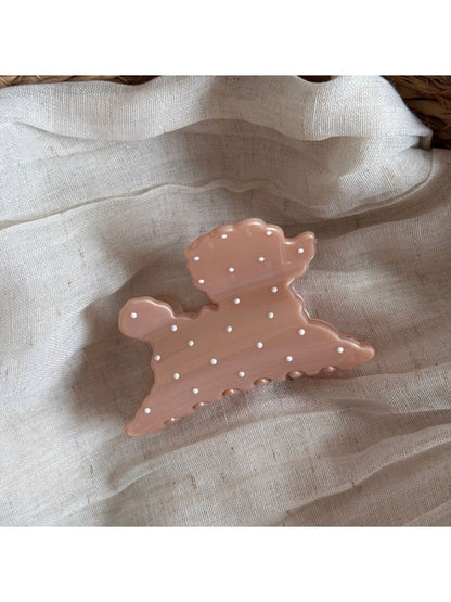 Side view of Beau polka dot puppy hair clip displaying its curved shape and clasp