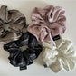 Close-up of vintage pleated fabric scrunchie in soft pastel color on white background