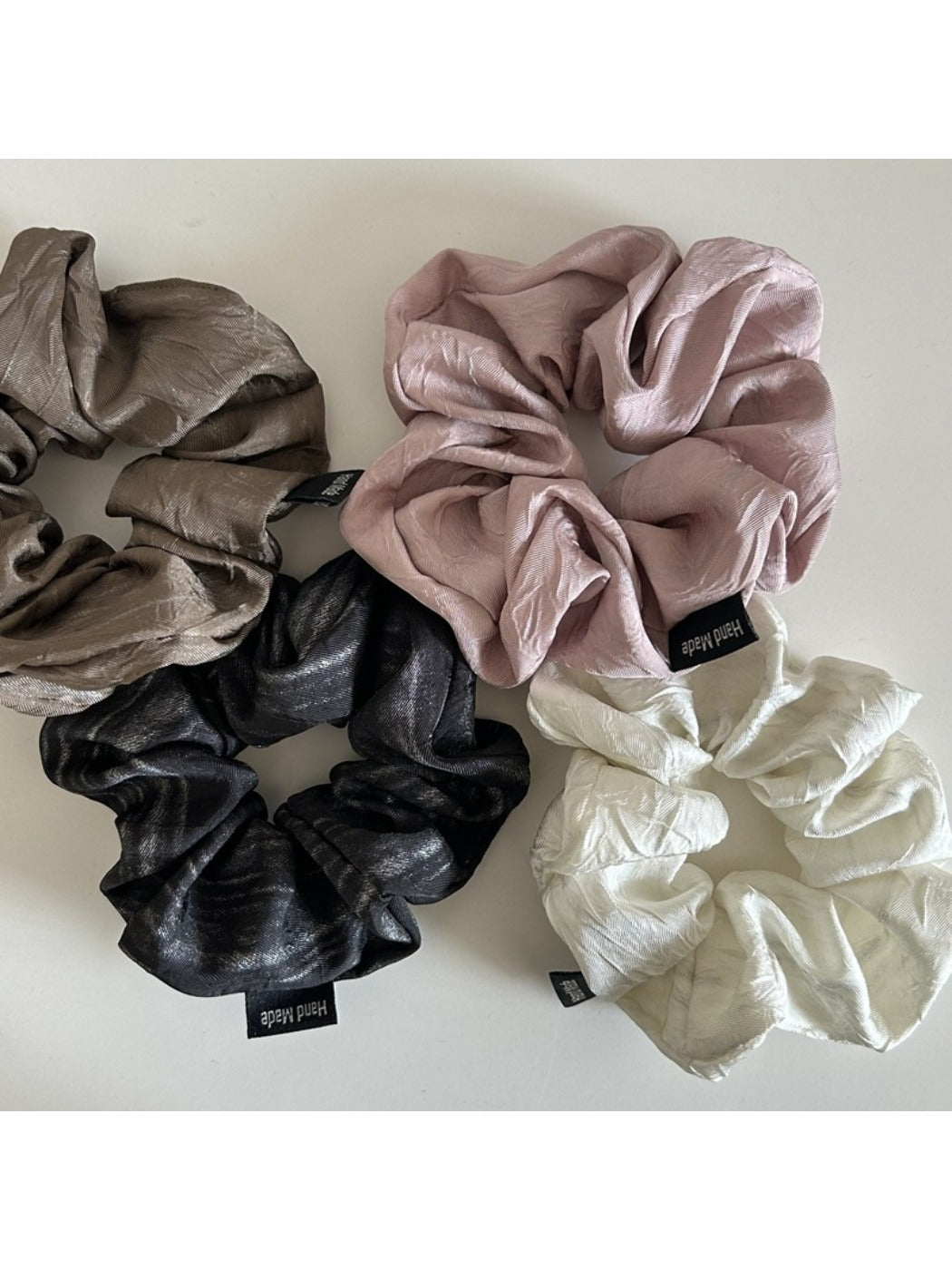 Close-up of vintage pleated fabric scrunchie in soft pastel color on white background