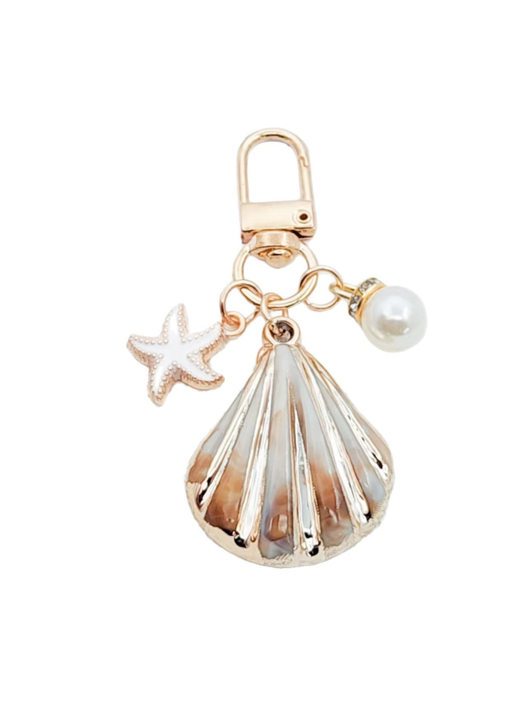 Gold conch keychain attached to a set of keys on a wooden surface