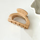 Beau claw clip in use holding hair, showcasing its semi circular shape and openwork style