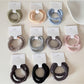 Close-up of Gifty minimalist satin hair tie in soft pink on white background