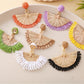 Earedge raffia fan shaped drop earrings displayed hanging on a stand