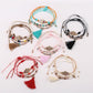 Lovra alloy charm tassel pendant bracelet on white background