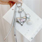 Close-up of silver heart keychain showing detailed metal texture and keyring