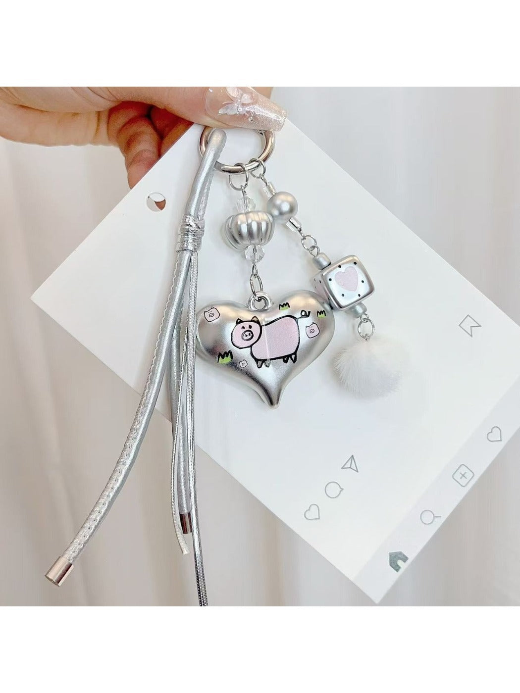 Close-up of silver heart keychain showing detailed metal texture and keyring