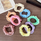 Set of colorful ruffled hair ties displayed on a wooden surface