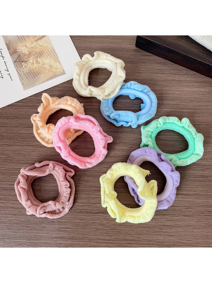 Set of colorful ruffled hair ties displayed on a wooden surface