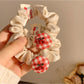 Gifty Sweet Plaid Cherry Hair Tie styled on a ponytail with visible cherry charm