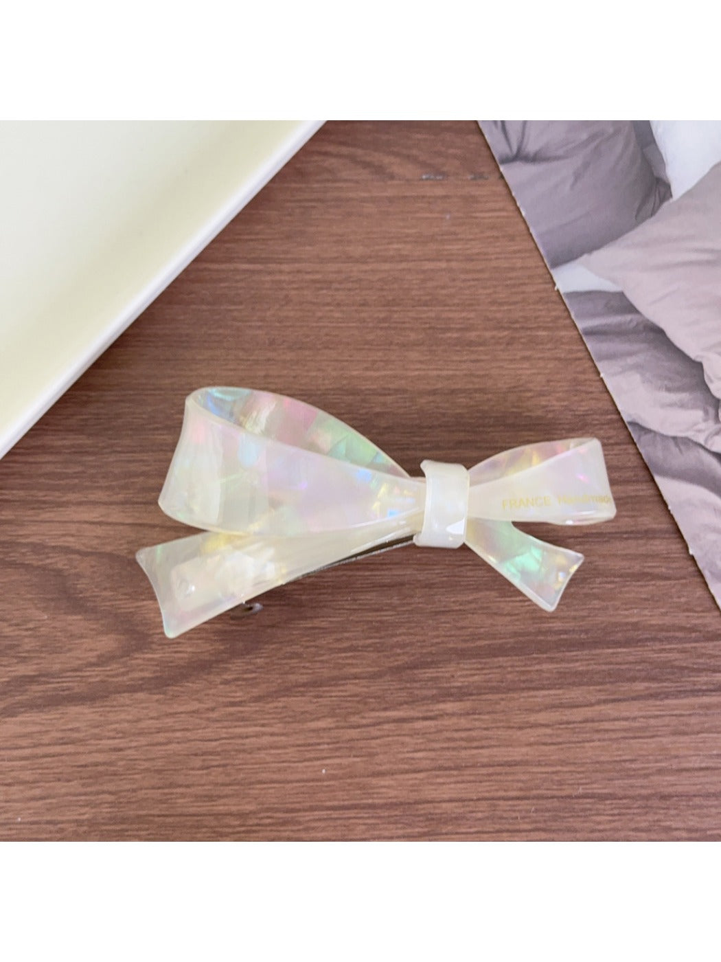 Beau acetate bow hair clip with light reflections emphasizing glossy finish