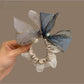Top view of bow hair tie showing fabric texture and elastic band