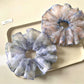 Close-up of a beige scrunchie with subtle vintage floral print