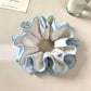 Gifty scrunchie styled on a wrist with neutral outfit, highlighting minimalist fashion