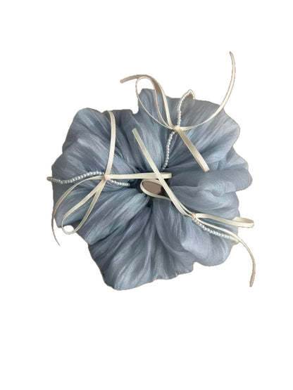 Blue tulle scrunchie with ribbon bow displayed on a wooden surface